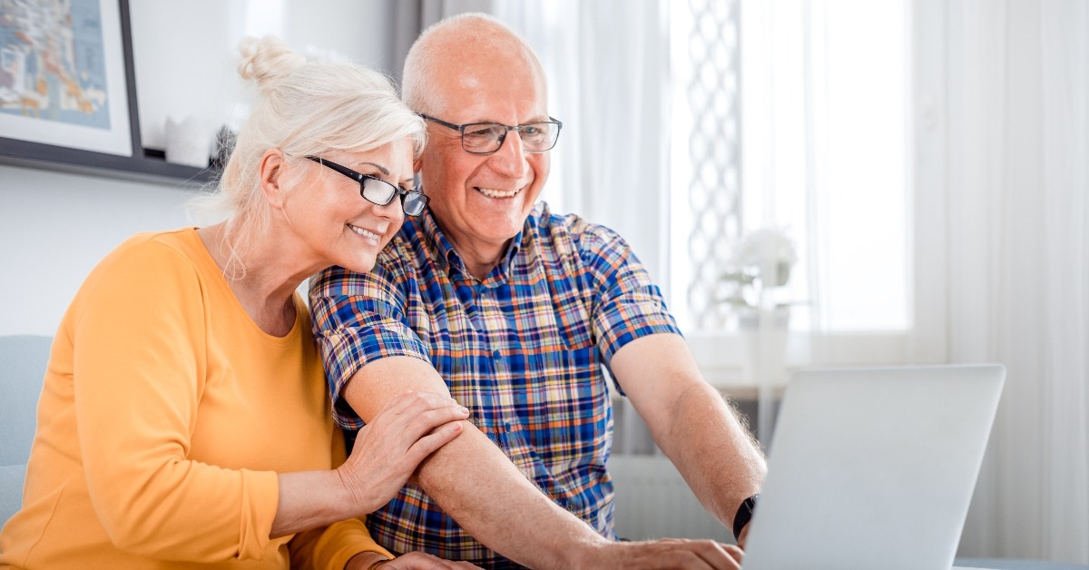 senior couple checking bills using laptop