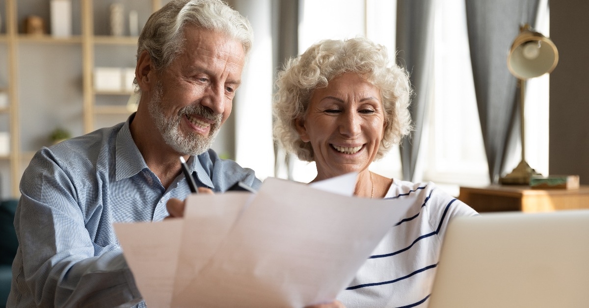 senior couple use online banking on laptop
