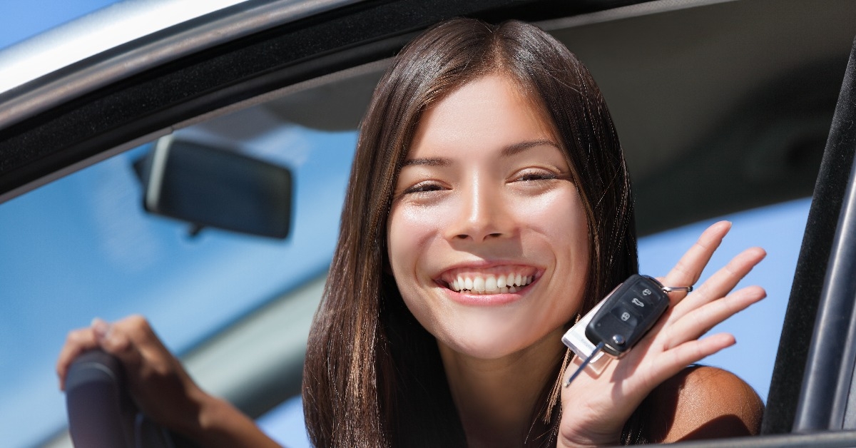 smiling asian girl teen driver showing car key