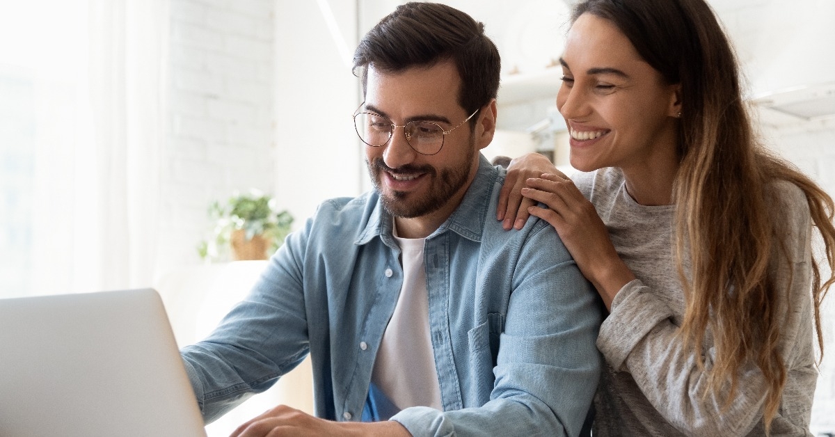 smiling couple using laptop