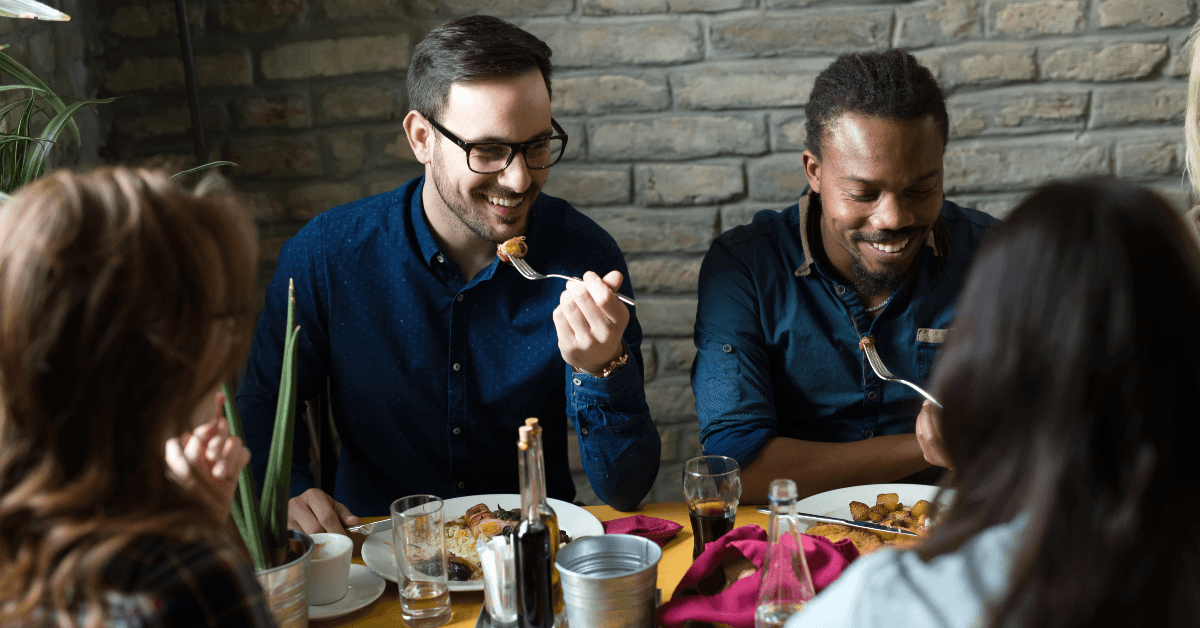 Happy friends eating dinner