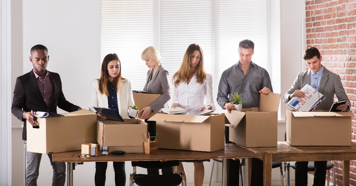 businesspeople packing belongings in cardboard box