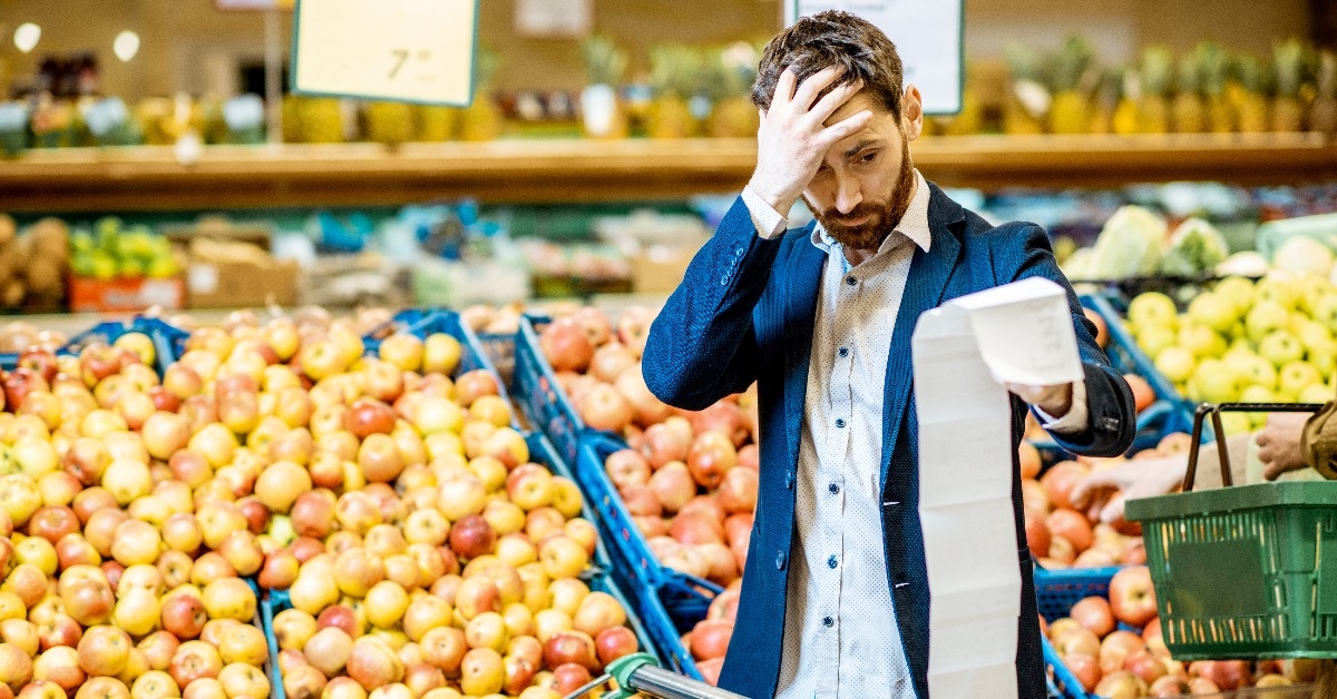 elegant man with shocked emotions holding very long shopping list 