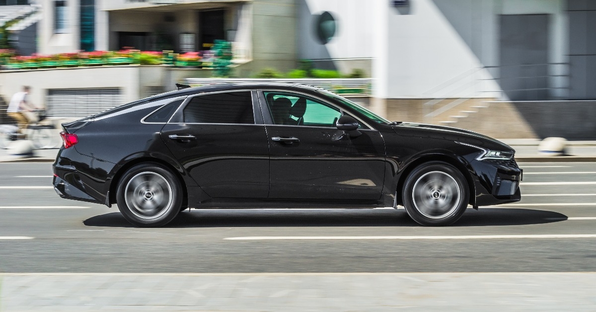 black KIA K5 against urban background