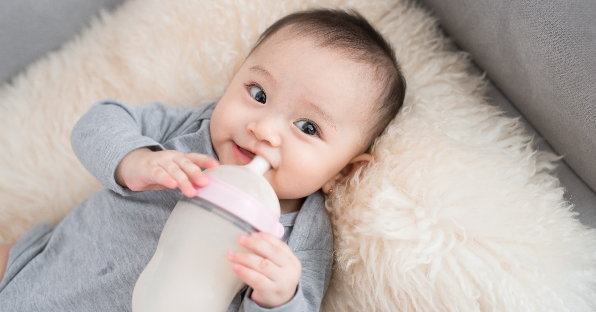 asian baby infant drinking milk from bottle