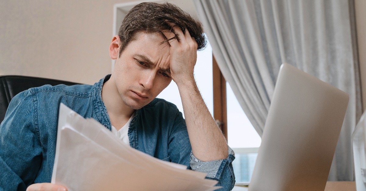 unhappy young man sitting in home office