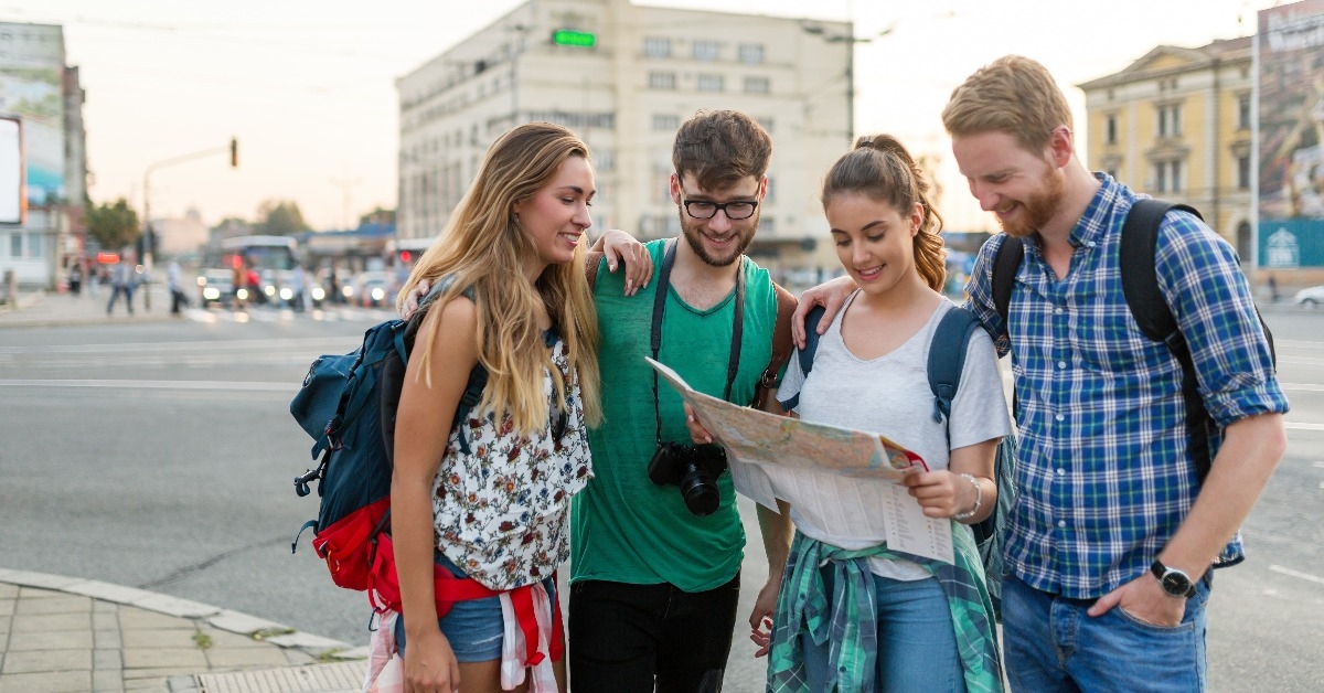 young happy tourists sightseeing in city