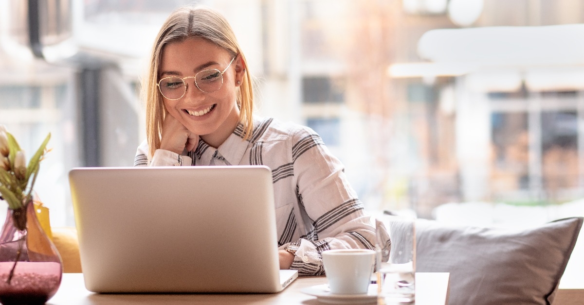 young woman using laptop at cafe