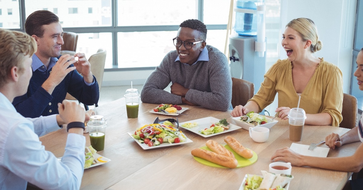 happy business colleagues having lunch at office cafeteria