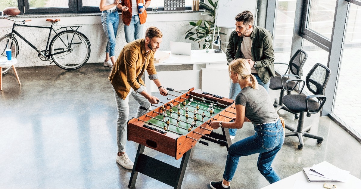 young casual business people playing table football