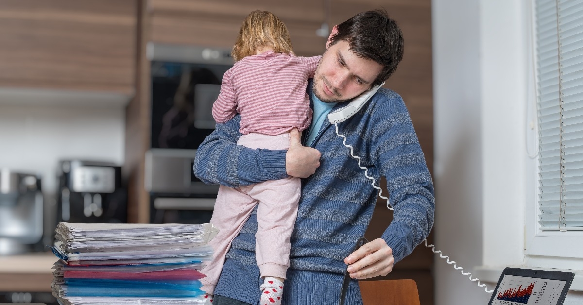 multitasking father is babysitting and working at home