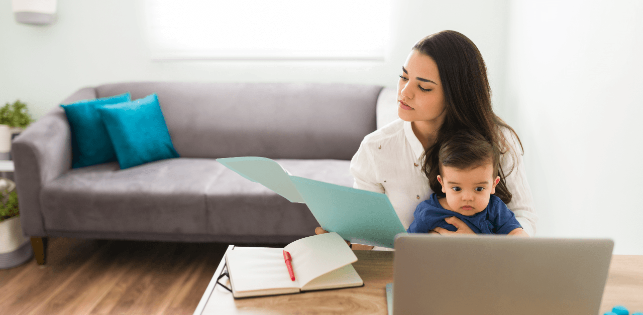 Woman working from home with child in lap