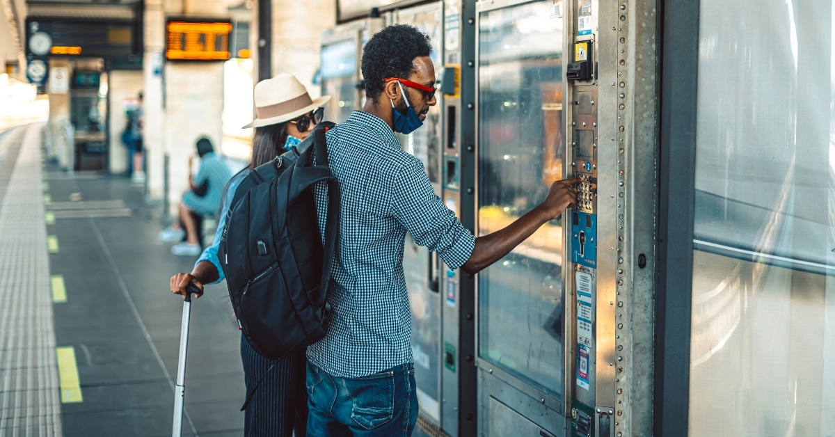 Couple buying snacks at airport vending machine