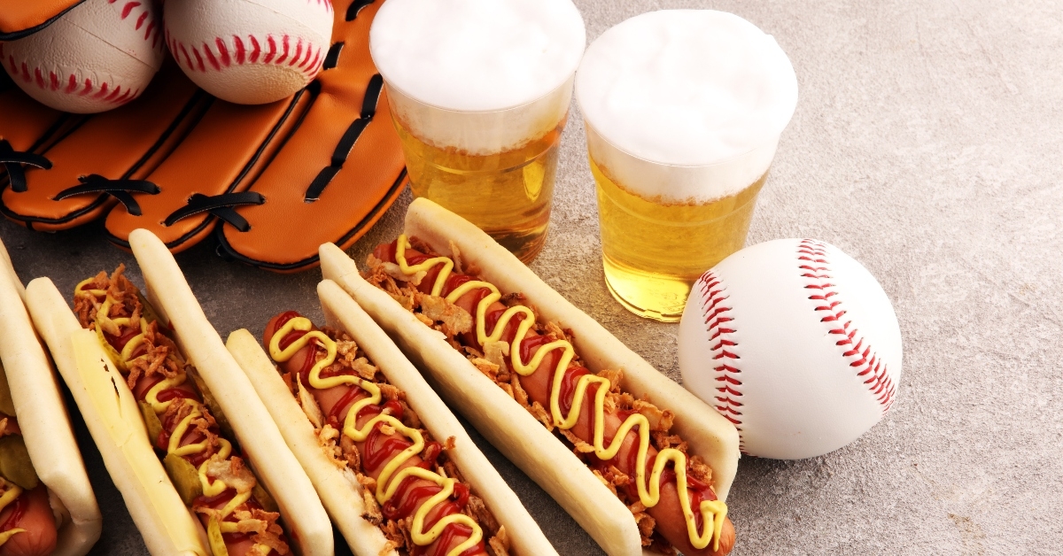 Hot dogs and beers next to baseballs