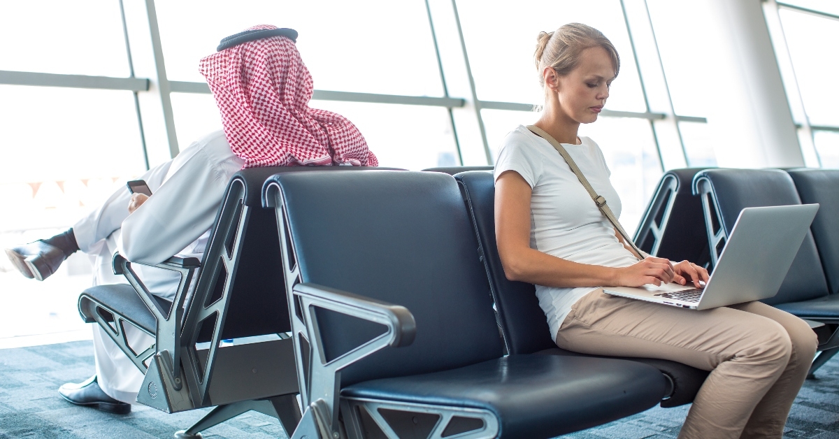Woman waiting at airport on computer