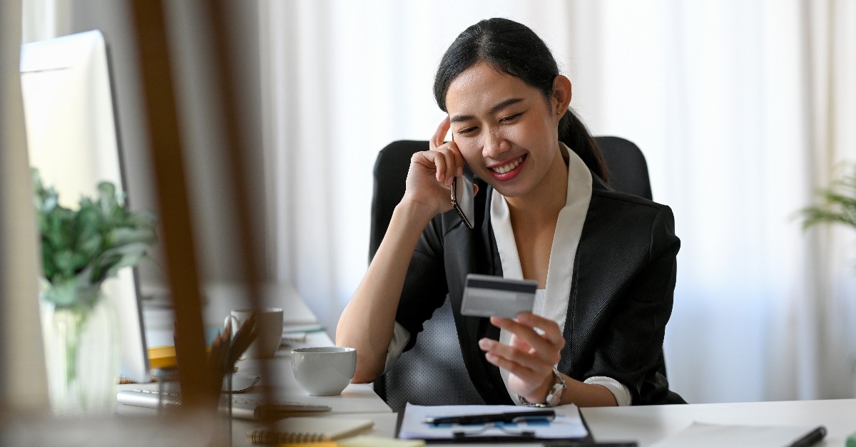 businesswoman talking on the phone with credit card agent