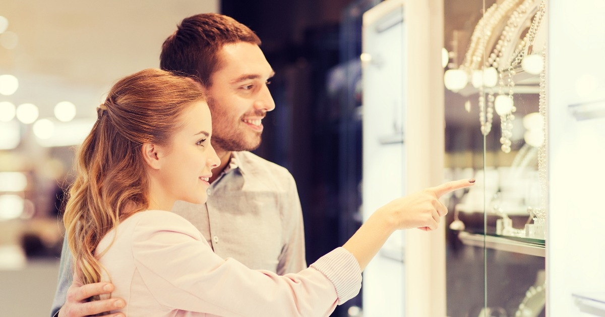 couple looking to shopping window at jewelry store