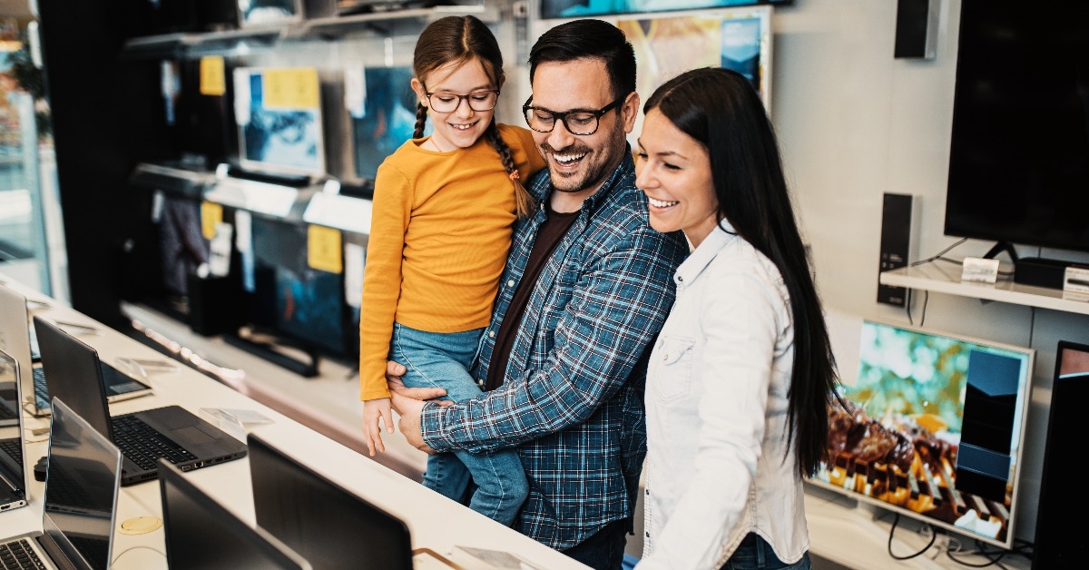 happy family buying laptop in store