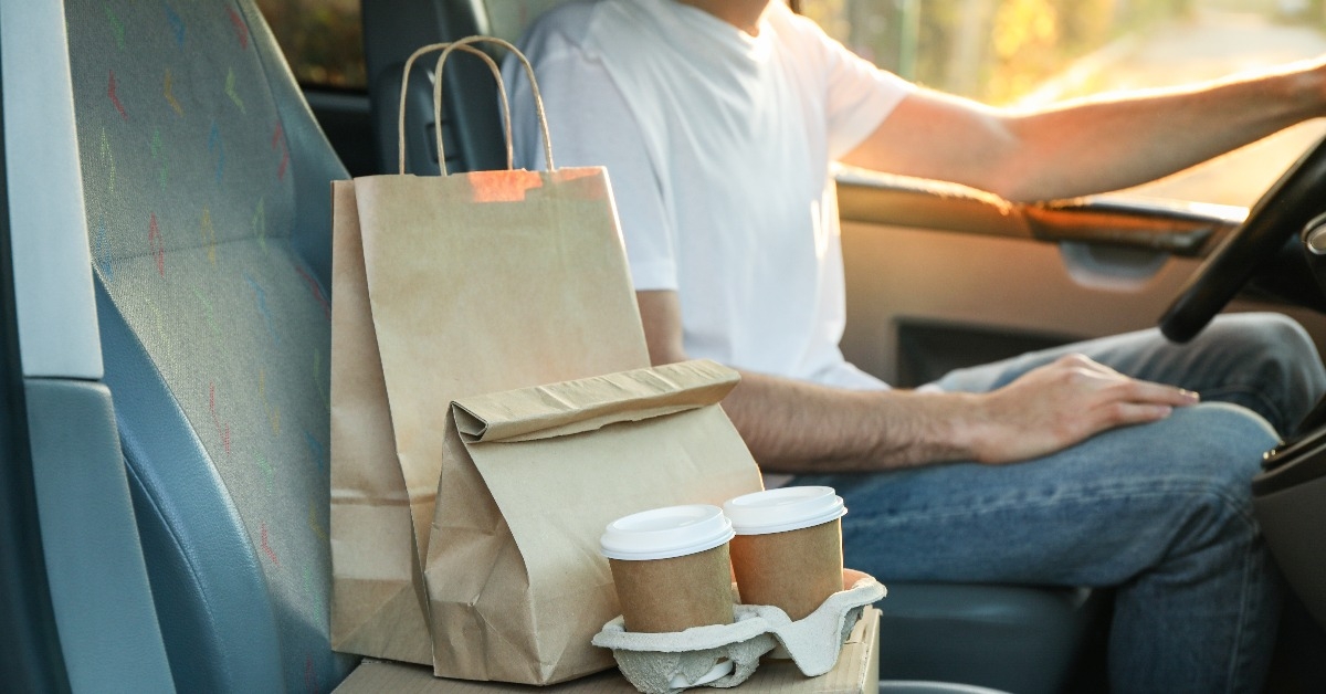 coffee cups paper packages and courier in car