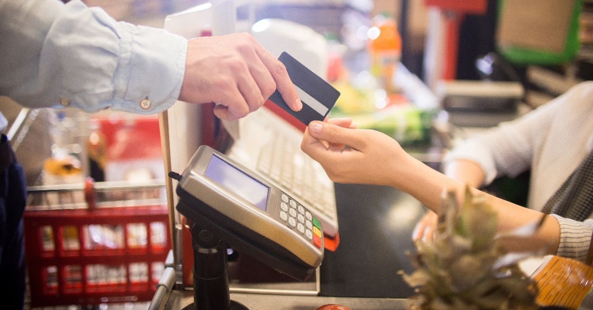 customer handing credit card to cashier paying via bank terminal