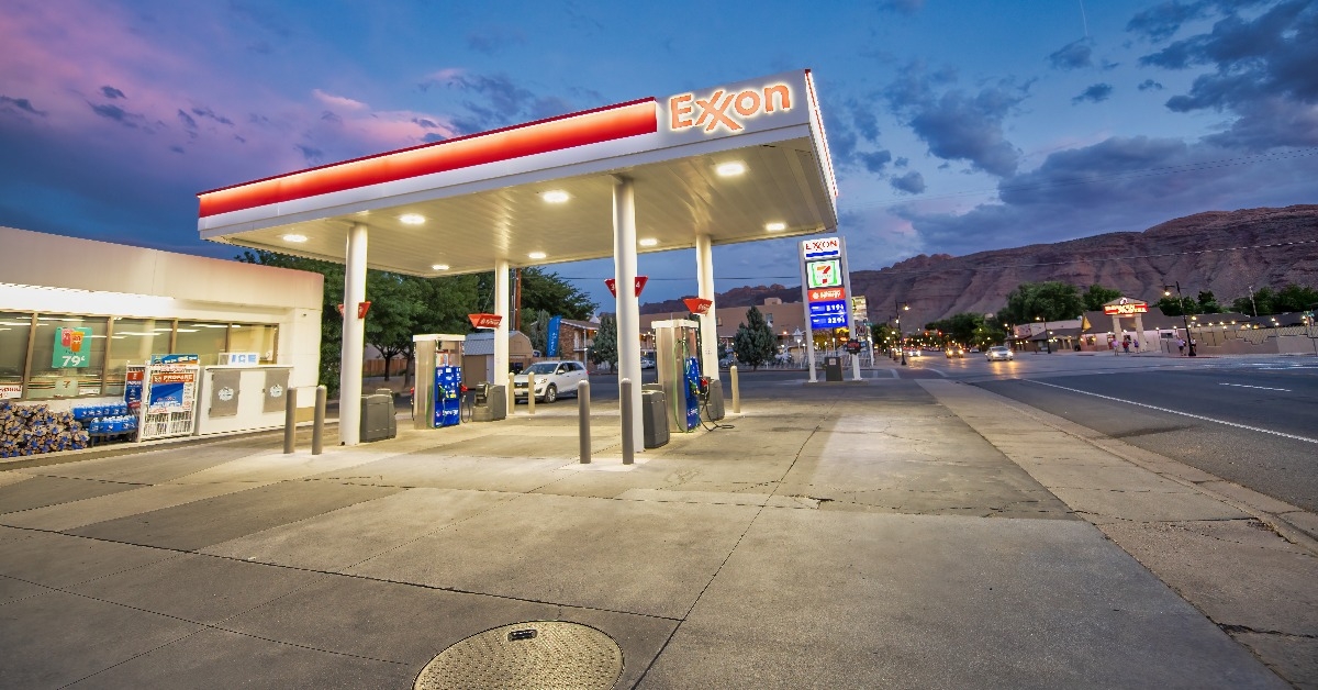 exxon gas station at night with red colors and cars refueling