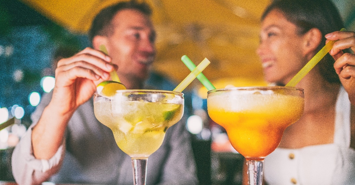 couple drinking giant margaritas at a cocktails party