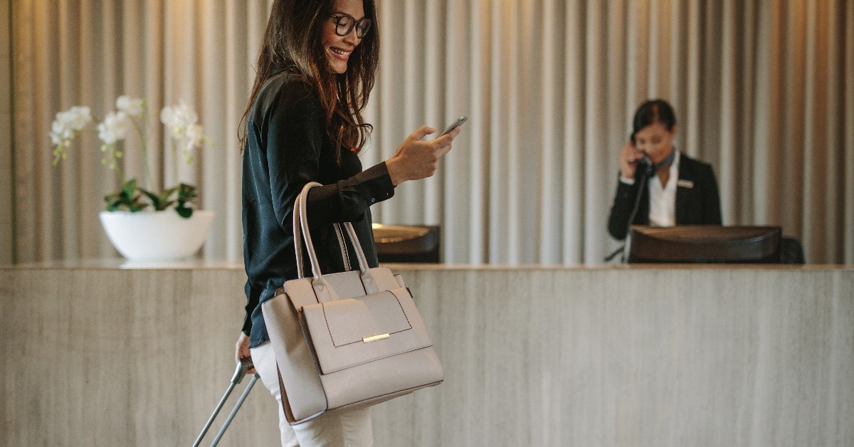 business traveler in hotel hallway with phone