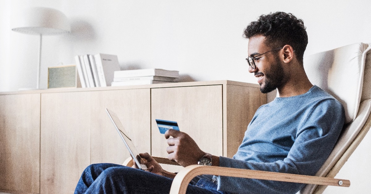 young man using digital tablet with credit card