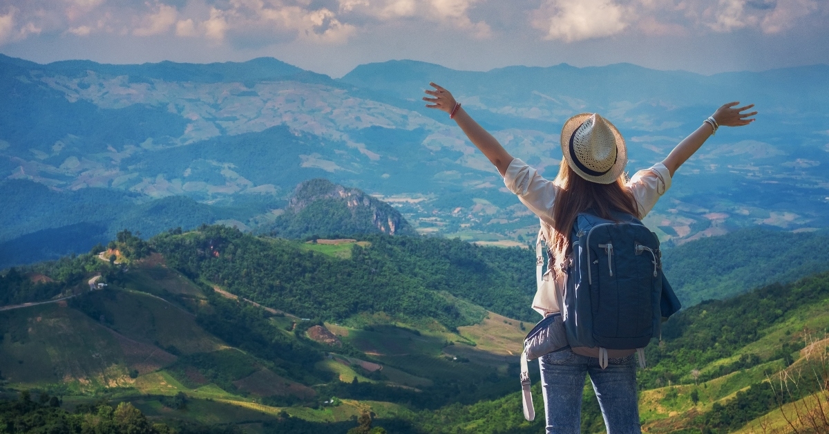 traveler girl standing with raised arms