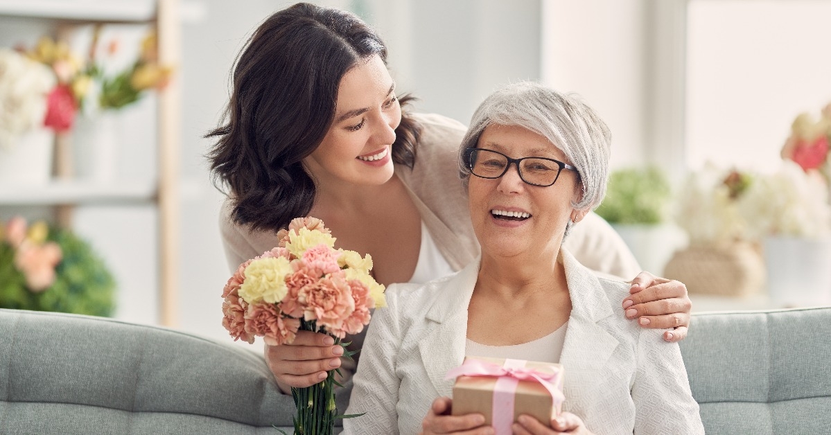 daughter greeting her mother with a gift on mother's day