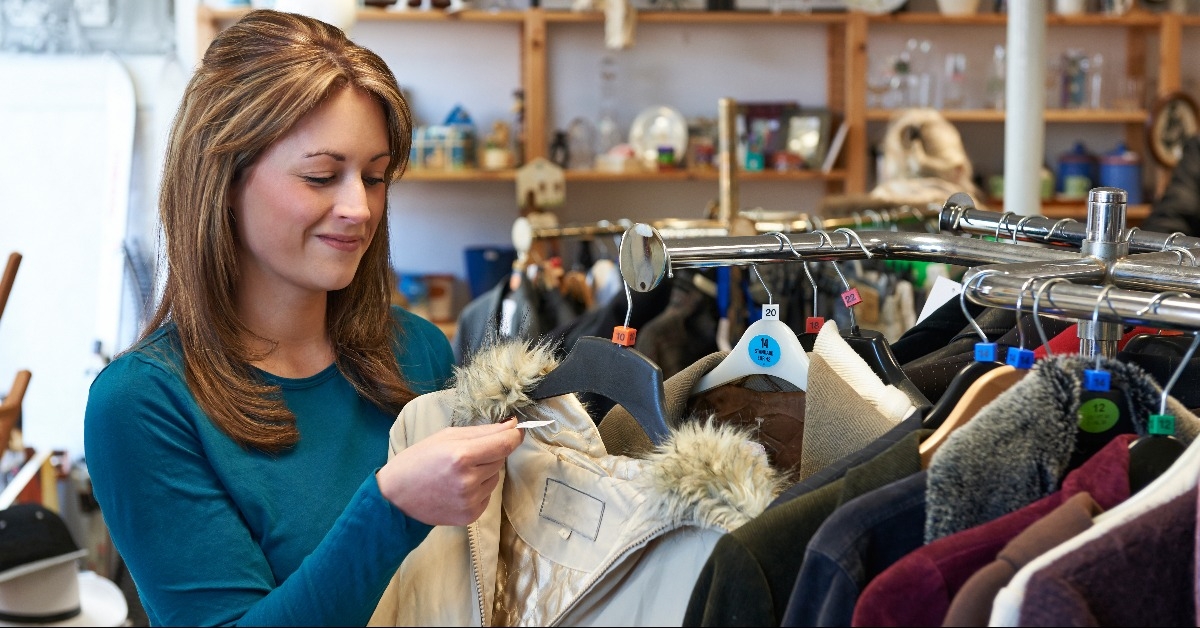 female shopper in thrift store looking at clothes