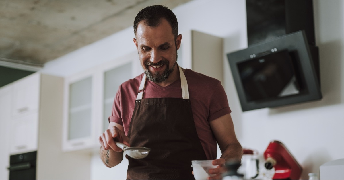 happy man sifting powdered sugar