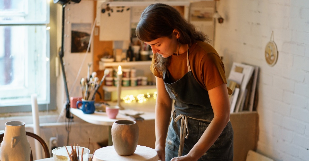  young woman work in ceramics studio on handicraft jar production