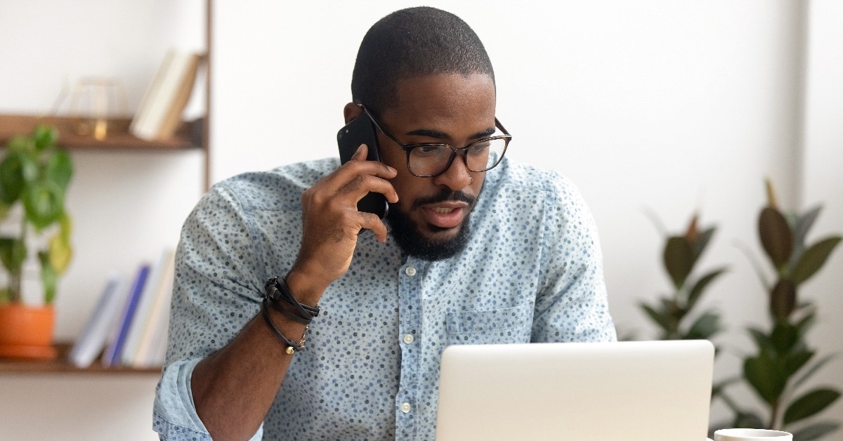 Serious african-american employee making business call