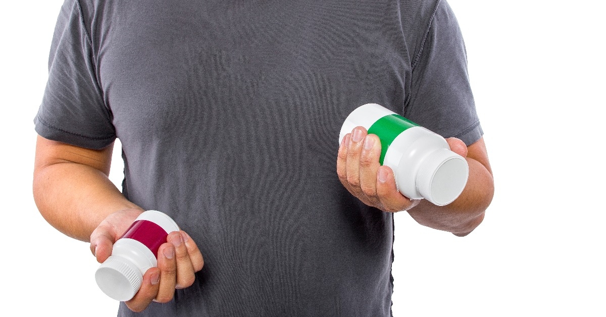 male comparing bottles of medicine