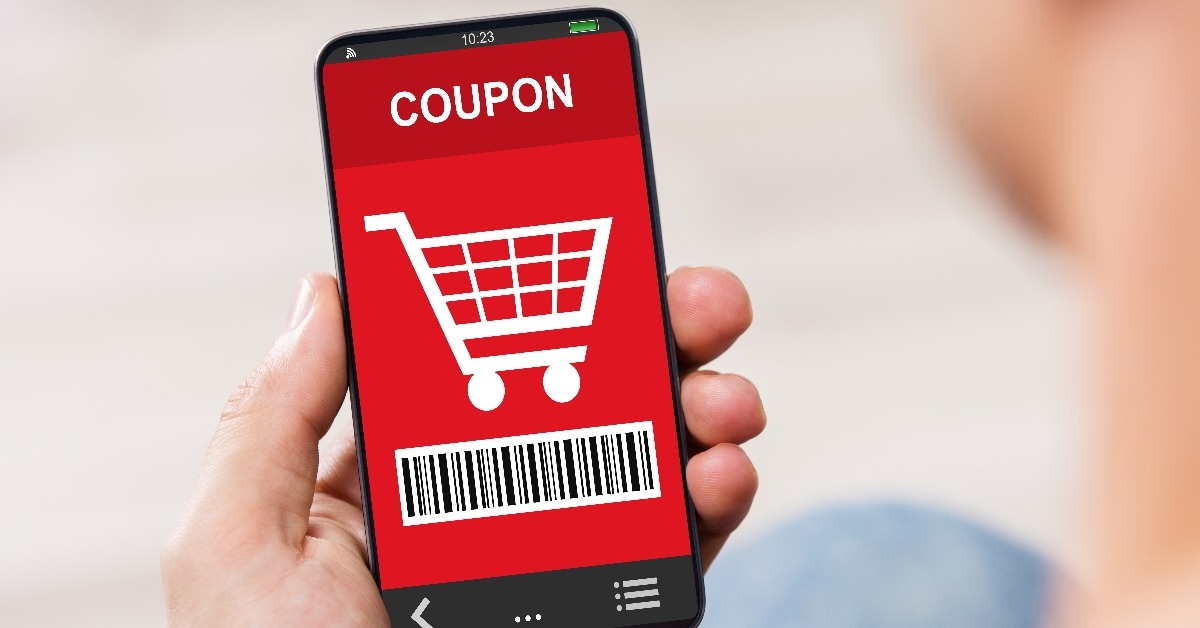 man's hand holding cell phone with coupon on the screen