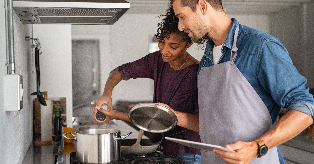 woman adding salt in pot while cooking