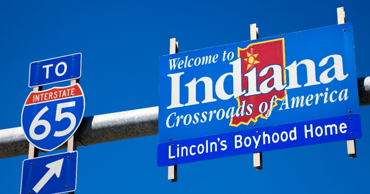 Welcome to Indiana road sign against blue sky.