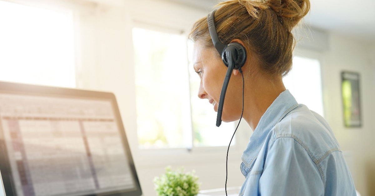 Customer service operator talking on phone in office