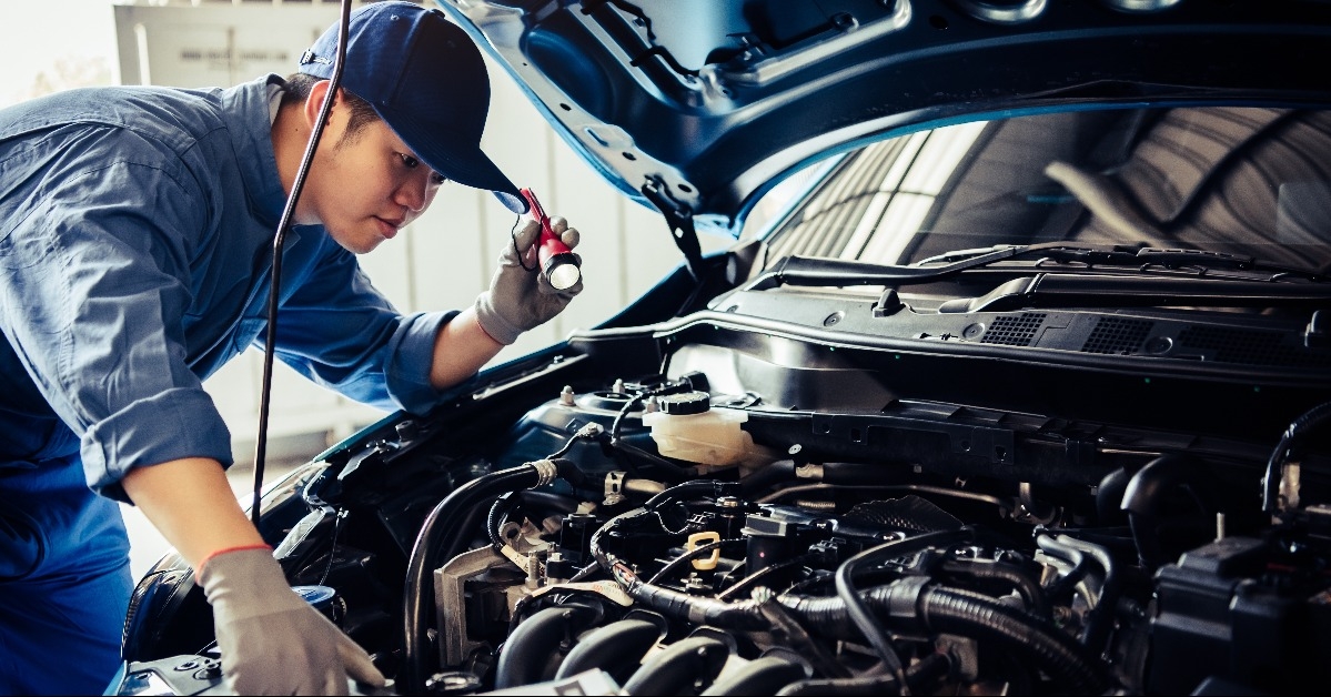 car mechanic technician holding flashlight 