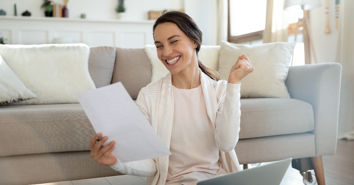 remote employee reading paper letter from company informing she is hired 