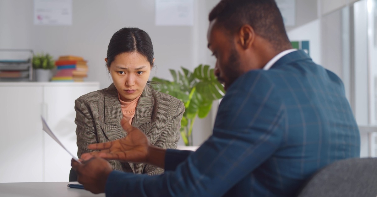 angry african male boss shouting at young female employee