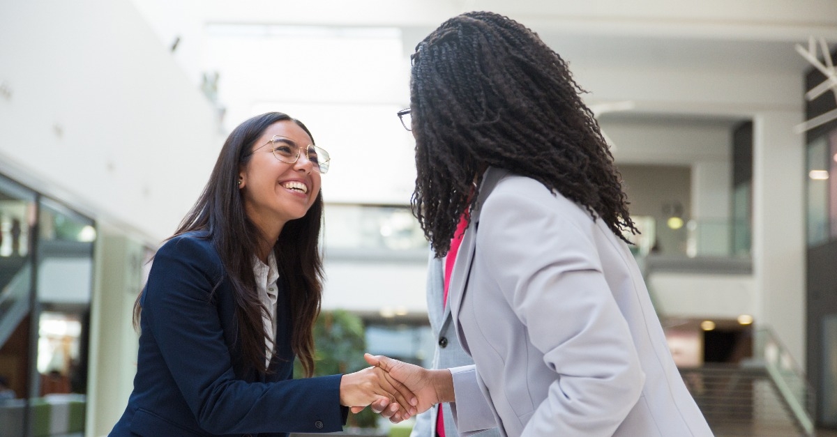  business partners greeting each other in hallway