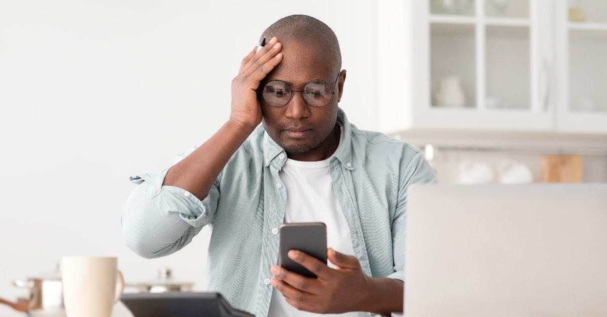 worried black mature man calculating utility charges and bills