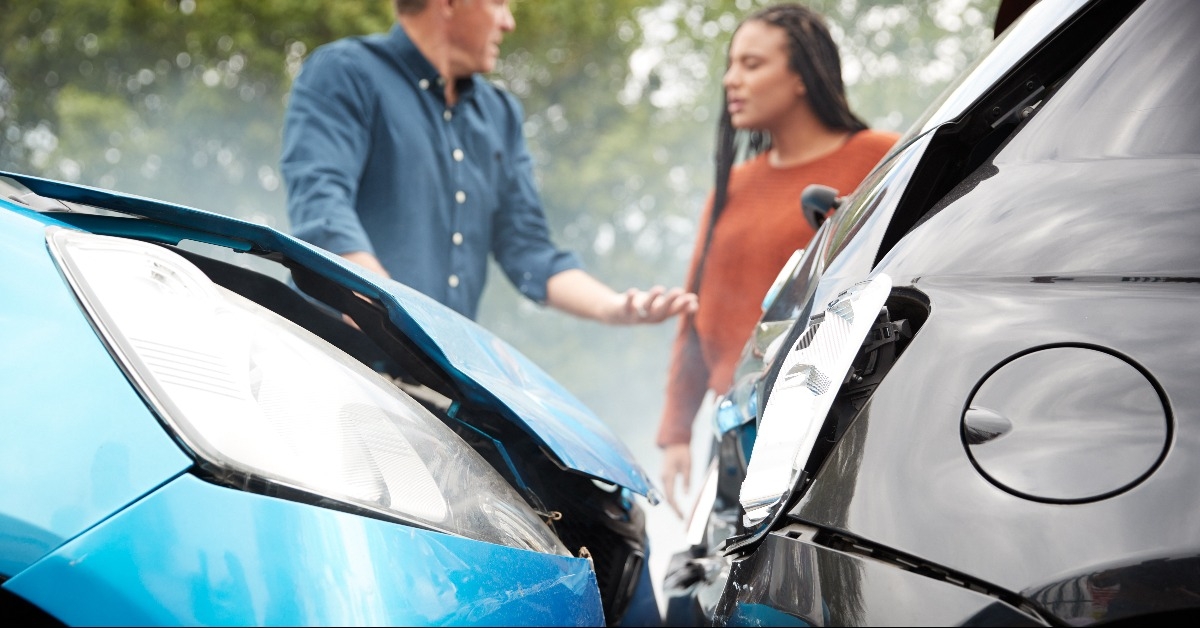 two angry motorists arguing over responsibility for car accident