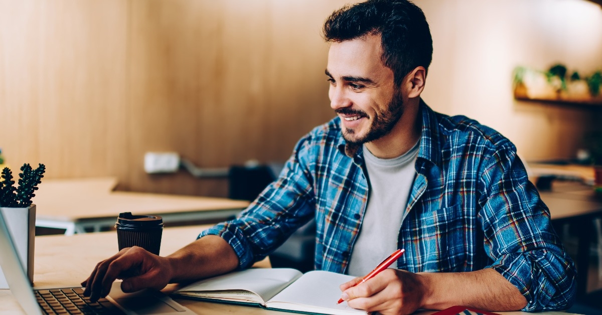 cheerful young male student enjoying training webinar on laptop 
