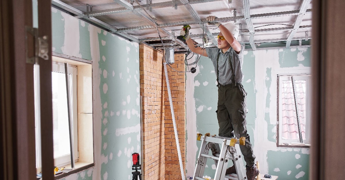 young builder makes a plasterboard ceiling