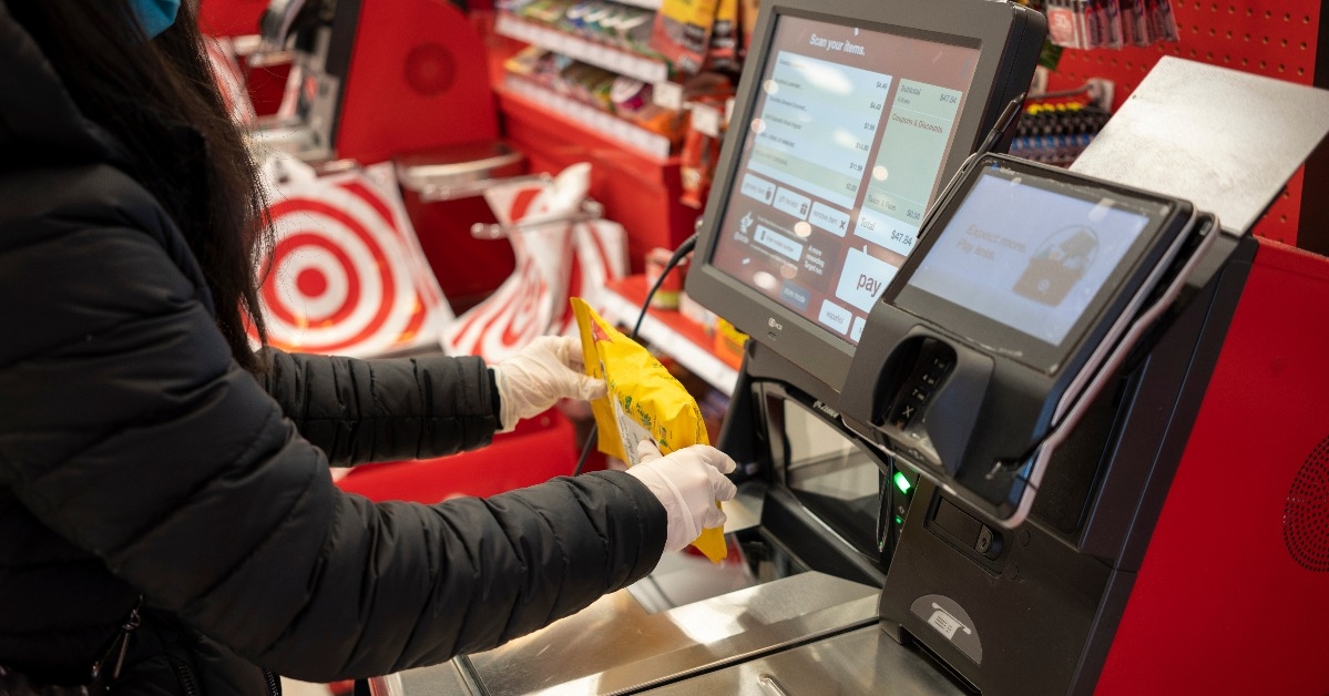 masked shopper in nitrile gloves scans a bag of Ricola cough drops