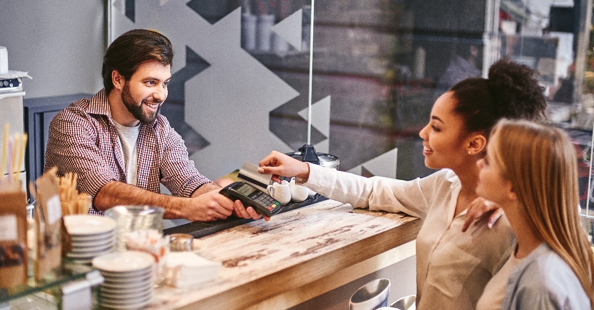 woman with credit card buying coffee at cafe 