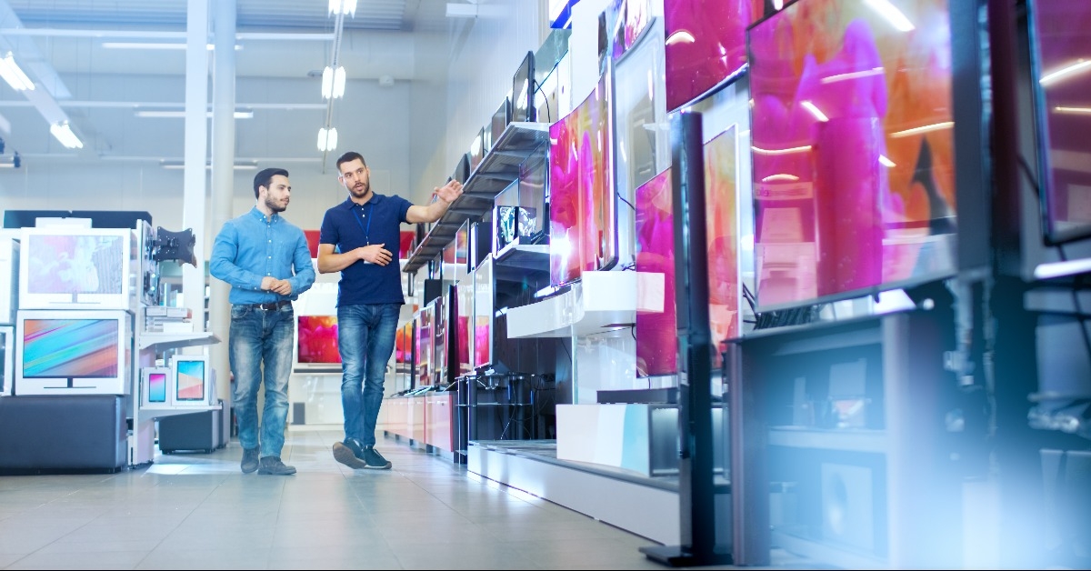 consultant shows latest uhd tv's to a young man